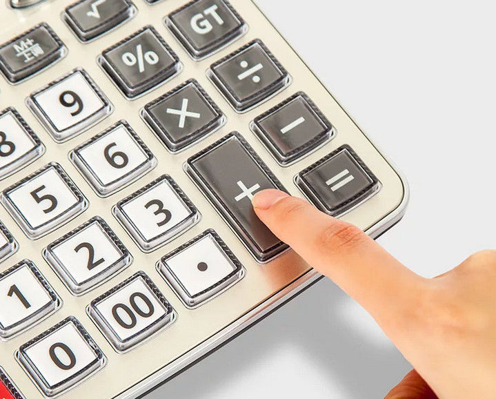Девушка кладет палец на калькулятор